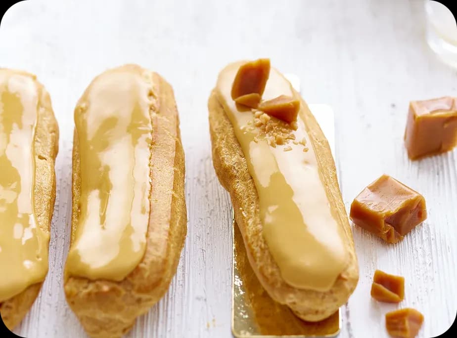 Caramel éclairs on a white table